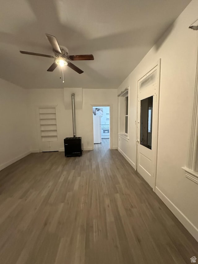 unfurnished living room featuring wood finished floors, a ceiling fan, and baseboards
