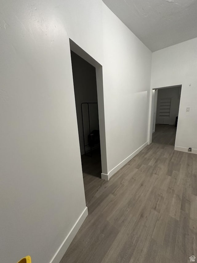 hallway featuring wood finished floors and baseboards