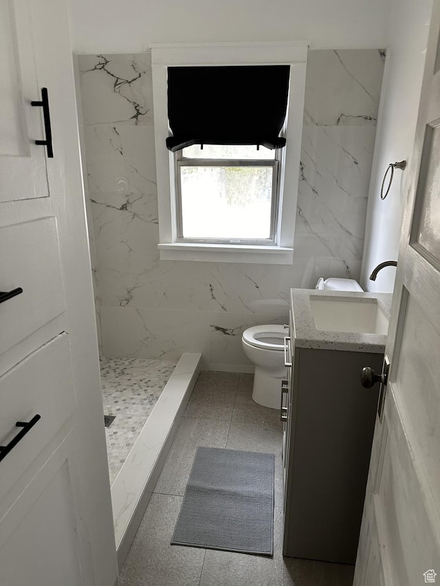 full bath with vanity, a marble finish shower, and toilet