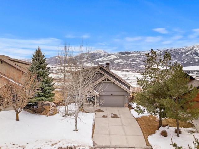 view of front of property featuring a garage, a mountain view, and concrete driveway