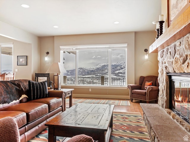 living room with a fireplace, a mountain view, wood finished floors, and recessed lighting