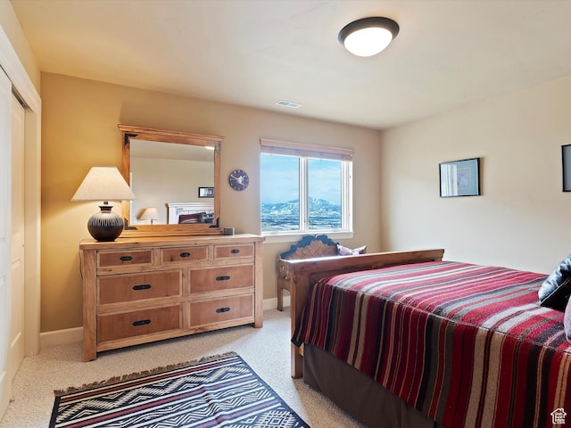 bedroom featuring baseboards, visible vents, and light colored carpet