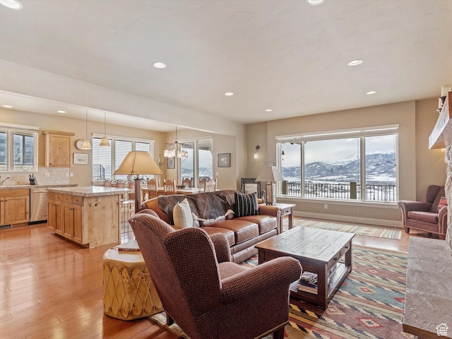 living area featuring recessed lighting, a mountain view, light wood finished floors, and an inviting chandelier