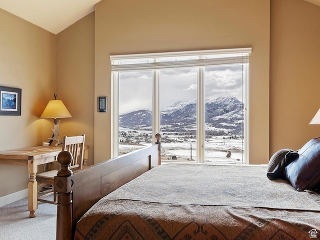 carpeted bedroom featuring vaulted ceiling, a mountain view, and baseboards