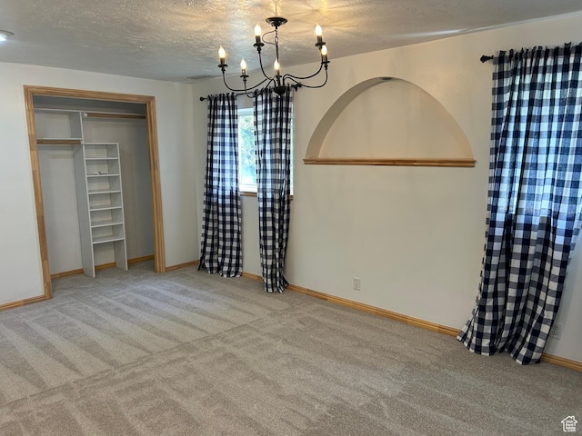 829 E 1925 N, North Ogden, UT 84414 - unfurnished bedroom with a chandelier, a textured ceiling, carpet flooring, baseboards, and a closet
