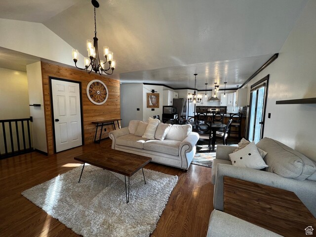 living area featuring dark wood-style floors, vaulted ceiling, a notable chandelier, and wooden walls