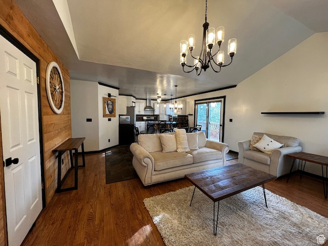 living room with dark wood finished floors, vaulted ceiling, and a notable chandelier