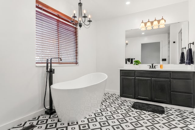 full bath with a freestanding bath, a notable chandelier, vanity, and baseboards