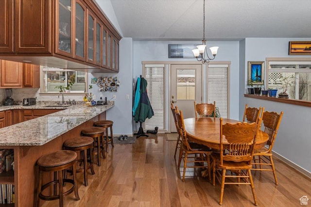 3879 S Mcgregor Ln, Saratoga Springs, UT 84045 - dining room with baseboards, a healthy amount of sunlight, light wood-type flooring, and an inviting chandelier
