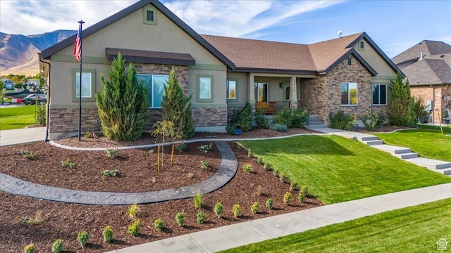 3879 S Mcgregor Ln, Saratoga Springs, UT 84045 - view of front of home featuring a front yard, stone siding, a mountain view, and stucco siding