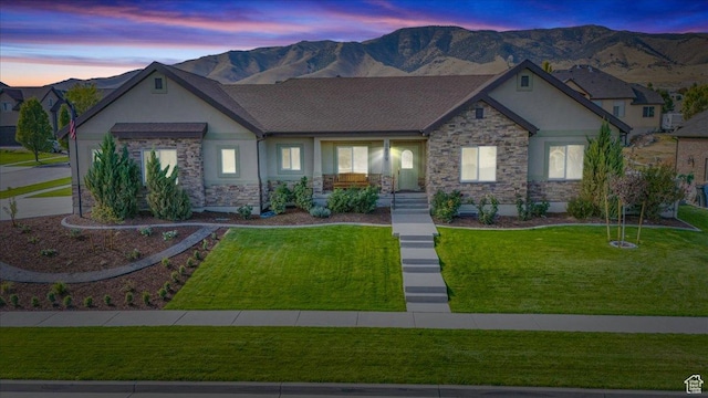 3879 S Mcgregor Ln, Saratoga Springs, UT 84045 - view of front facade featuring stone siding, a front yard, a mountain view, and stucco siding