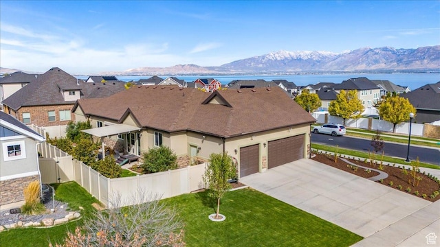 3879 S Mcgregor Ln, Saratoga Springs, UT 84045 - view of front facade with a garage, concrete driveway, a fenced backyard, a residential view, and a mountain view