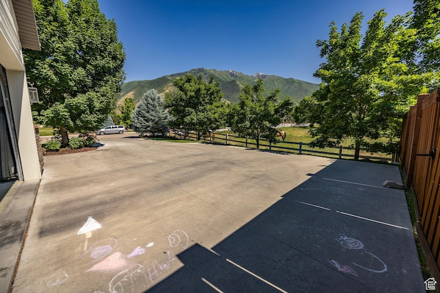 view of patio / terrace featuring fence and a mountain view