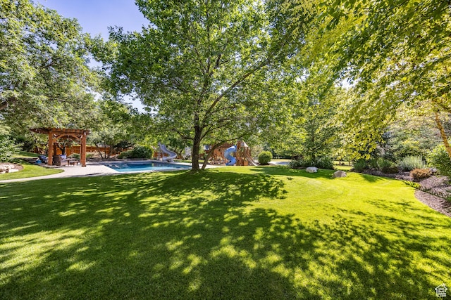 view of yard with a patio area, a playground, an outdoor pool, and a pergola