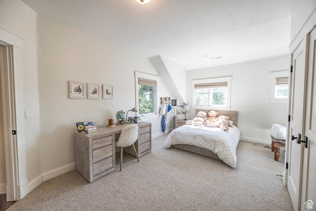 carpeted bedroom with baseboards and a textured ceiling