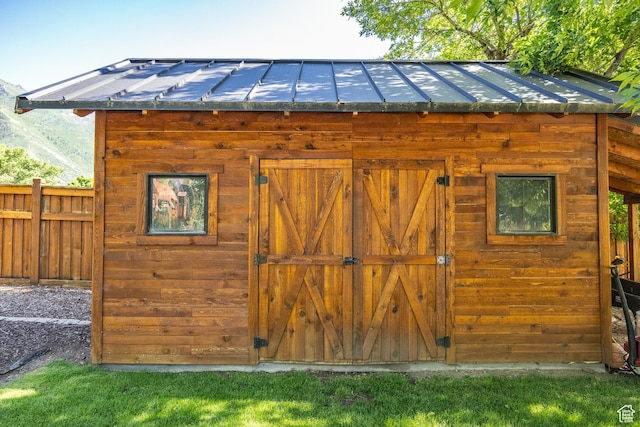 view of outdoor structure featuring fence and an outbuilding