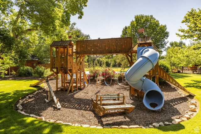 view of jungle gym with a lawn and fence