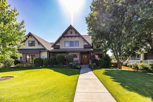 view of front facade featuring a standing seam roof, fence, a front lawn, and metal roof