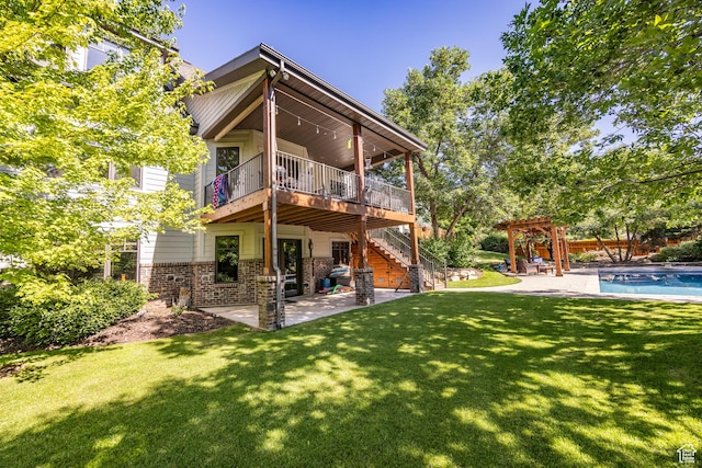 rear view of property with brick siding, a yard, a patio, stairway, and a wooden deck