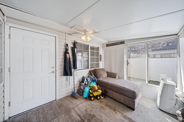 sunroom / solarium featuring a ceiling fan