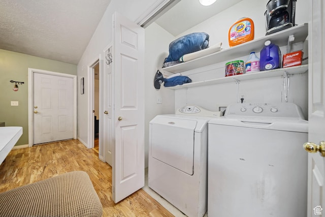 laundry room with laundry area, light wood finished floors, baseboards, a textured ceiling, and washing machine and dryer
