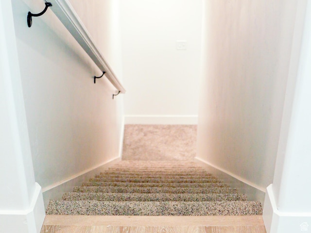 stairs featuring carpet flooring and baseboards