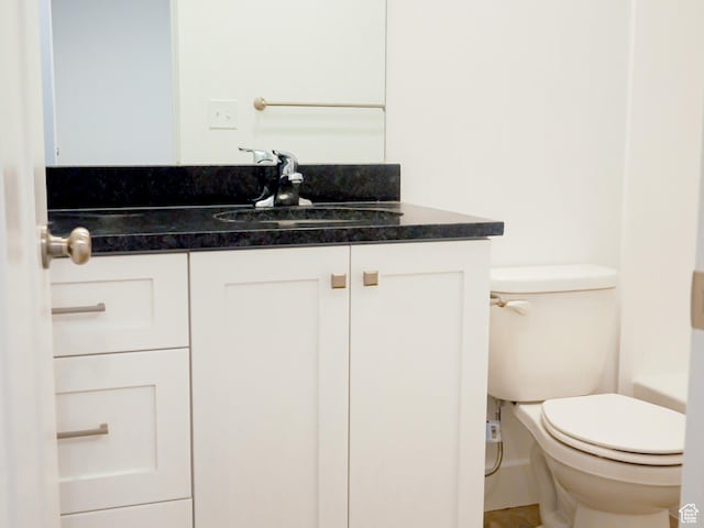 bathroom featuring vanity, toilet, and a bath