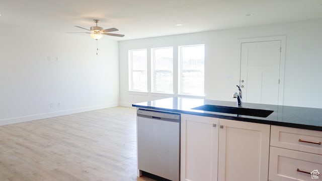 kitchen featuring white cabinets, a ceiling fan, light wood-type flooring, stainless steel dishwasher, and a sink