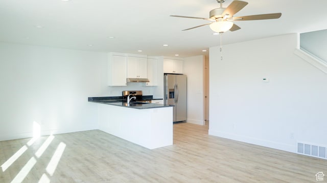 kitchen with light wood finished floors, visible vents, a peninsula, stainless steel refrigerator with ice dispenser, and a sink