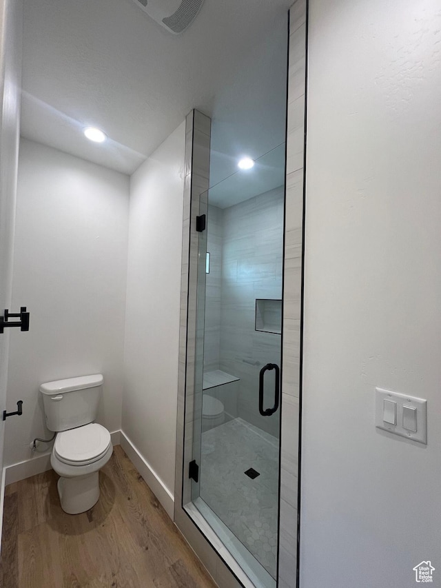 full bathroom with wood finished floors, baseboards, recessed lighting, a shower stall, and toilet