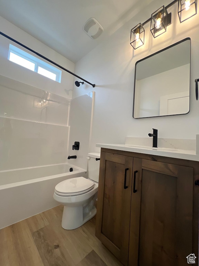 bathroom with vanity, shower / bathing tub combination, toilet, and wood finished floors