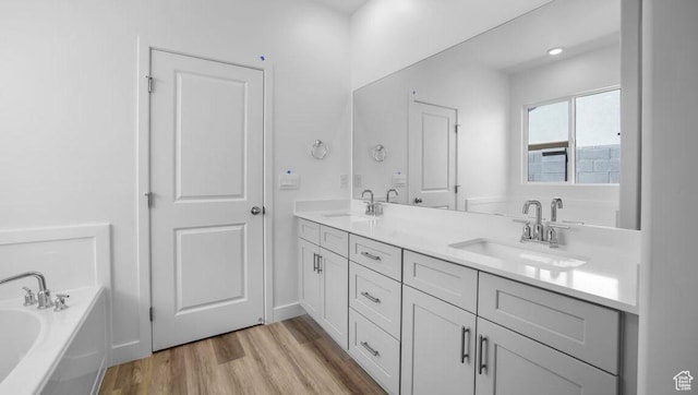 1726 S Wolverine Way Unit 174, Washington, UT 84780 - bathroom featuring a garden tub, double vanity, a sink, and wood finished floors