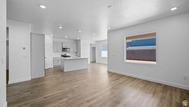 1726 S Wolverine Way Unit 174, Washington, UT 84780 - unfurnished living room with baseboards, recessed lighting, wood finished floors, and a sink