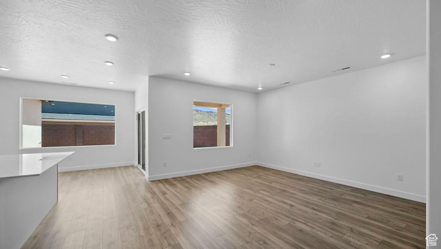 1726 S Wolverine Way Unit 174, Washington, UT 84780 - unfurnished living room featuring baseboards, recessed lighting, and wood finished floors