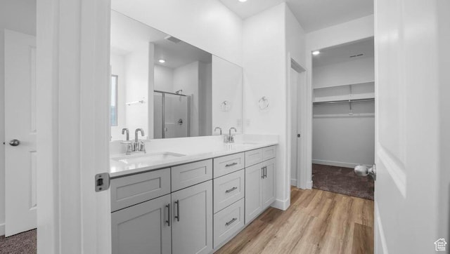 1726 S Wolverine Way Unit 174, Washington, UT 84780 - bathroom with a stall shower, wood finished floors, double vanity, and a sink