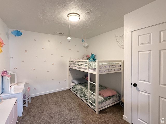 carpeted bedroom featuring baseboards, visible vents, and a textured ceiling