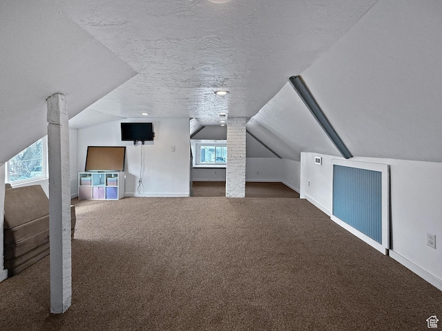 additional living space with lofted ceiling, a textured ceiling, baseboards, and carpet flooring