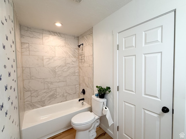 bathroom with wood finished floors, toilet, and shower / bathtub combination