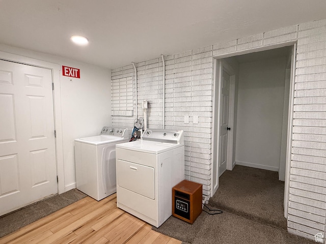 clothes washing area with light wood-style flooring and separate washer and dryer