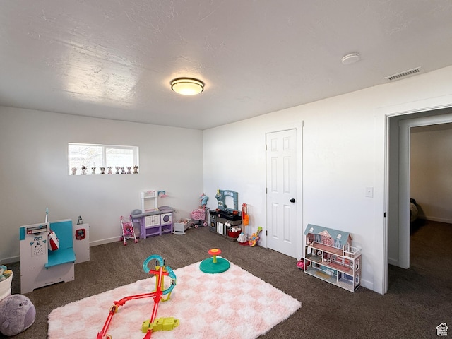 playroom featuring carpet, visible vents, and a textured ceiling