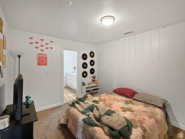 carpeted bedroom featuring visible vents, baseboards, and a textured ceiling