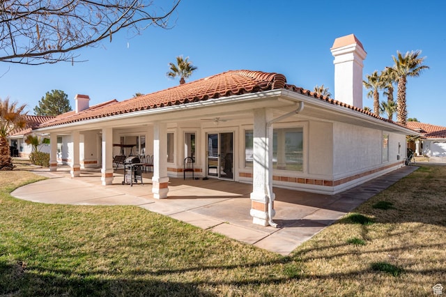 150 S Crystal Lakes Dr Unit 48, St George, UT 84770 - back of house with a lawn, a patio, a tile roof, a chimney, and stucco siding