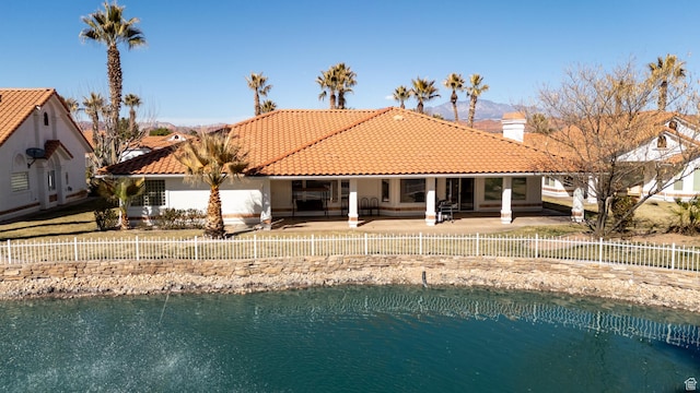 150 S Crystal Lakes Dr Unit 48, St George, UT 84770 - back of house featuring a fenced backyard, a tiled roof, stucco siding, a chimney, and a patio area