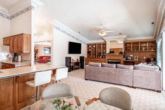 150 S Crystal Lakes Dr Unit 48, St George, UT 84770 - living area featuring a ceiling fan, a fireplace, light colored carpet, and crown molding