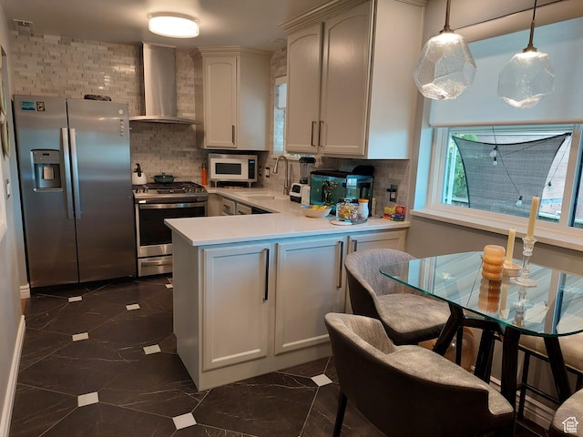 7688 S 1130 E, Midvale, UT 84047 - kitchen featuring wall chimney range hood, a sink, stainless steel appliances, a peninsula, and marble finish floor