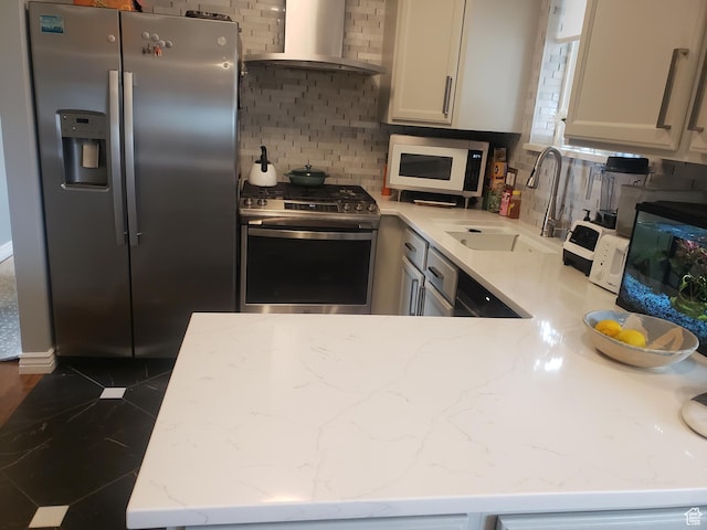 7688 S 1130 E, Midvale, UT 84047 - kitchen with light stone countertops, a sink, stainless steel appliances, backsplash, and wall chimney range hood