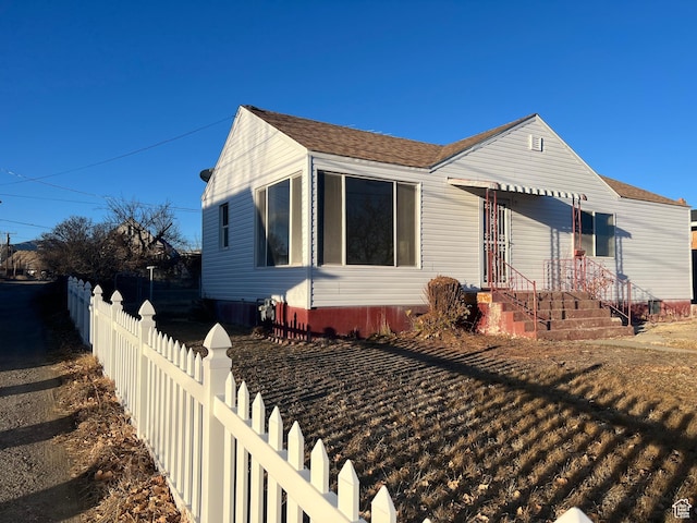 bungalow-style house with fence and roof with shingles