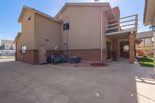 892 S Cambridge Dr, St George, UT 84770 - rear view of house featuring a balcony, a patio area, brick siding, and stucco siding