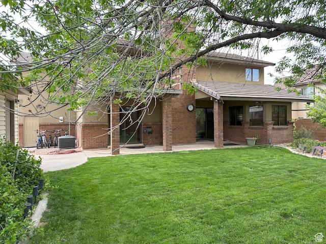 892 S Cambridge Dr, St George, UT 84770 - rear view of house with brick siding, a patio area, a lawn, and central AC unit