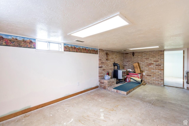 175 W 9200 S, Paradise, UT 84328 - basement with baseboards, a wood stove, a textured ceiling, and visible vents